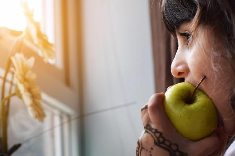 Une fillette dégustant une pomme verte